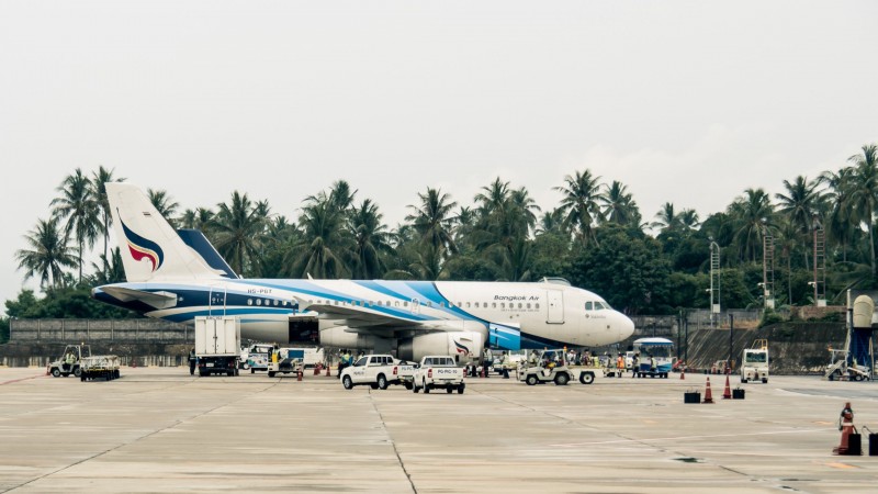 Flugzeug von Bagkok Air steht am Flughafen mit Palmen im Hintergrund