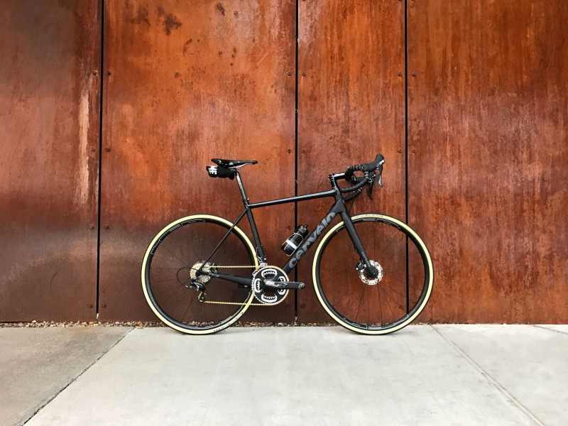 Schönes Rennrad vor einer dunkelbraunen Holzwand